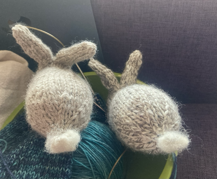 The two bunnies seen from the back, showing their fluffy white tails made from unspun white Jacob wool fleece.